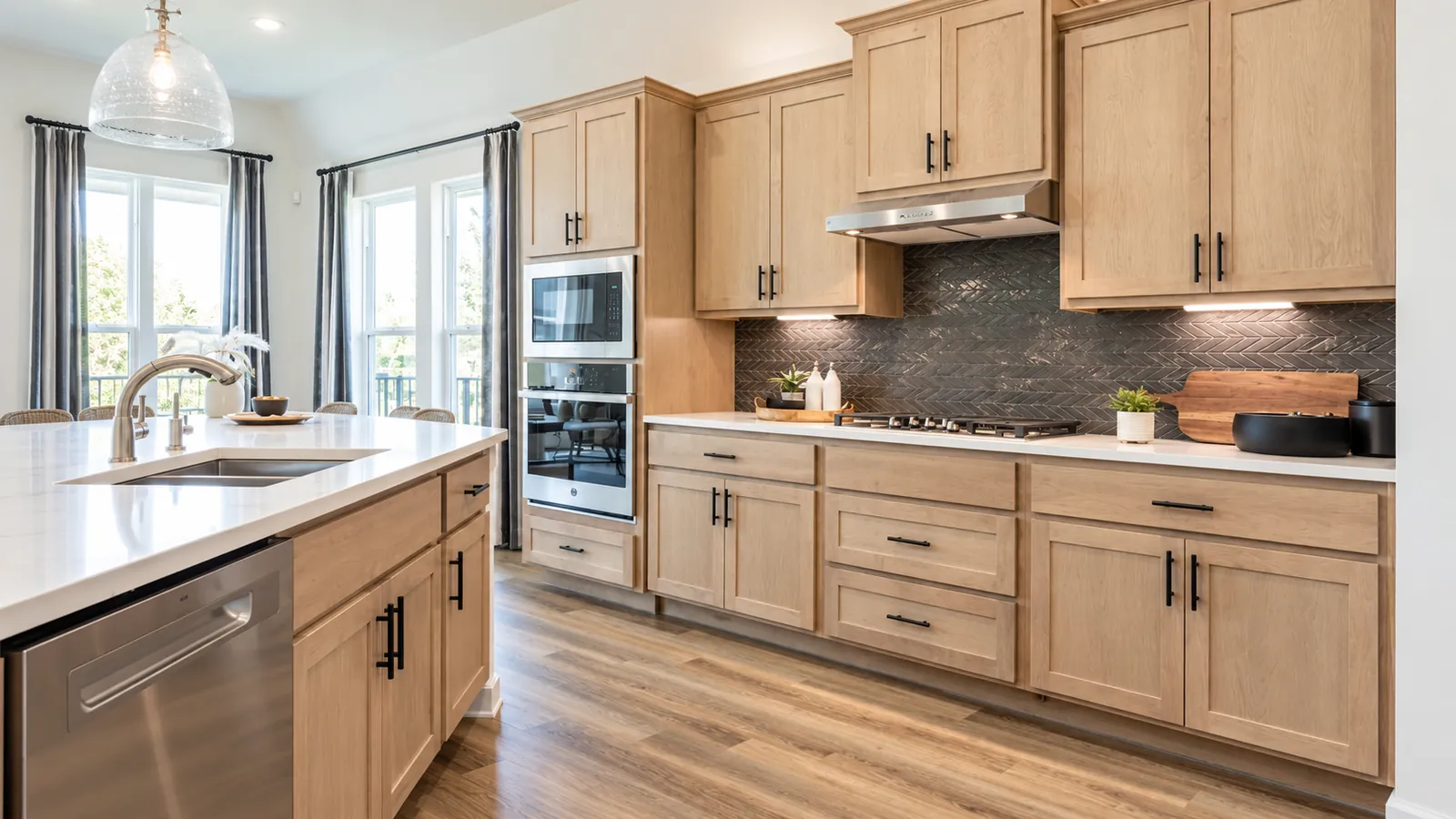 Light maple kitchen cabinets with a dark herringbone tile backsplash and quartz countertops