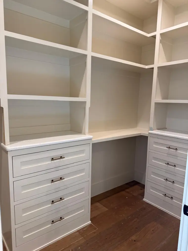 White walk-in closet built-in with drawer towers and open shelving