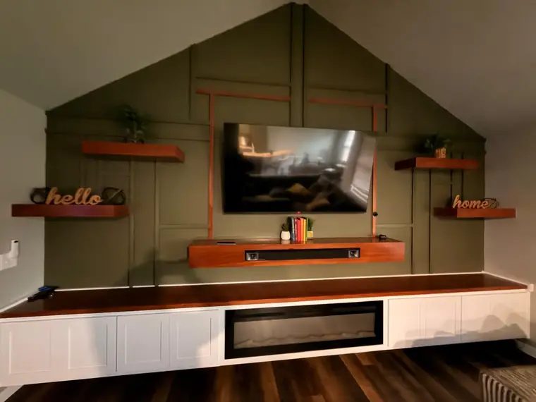 Olive panelled media wall with floating shelves and a linear fireplace
