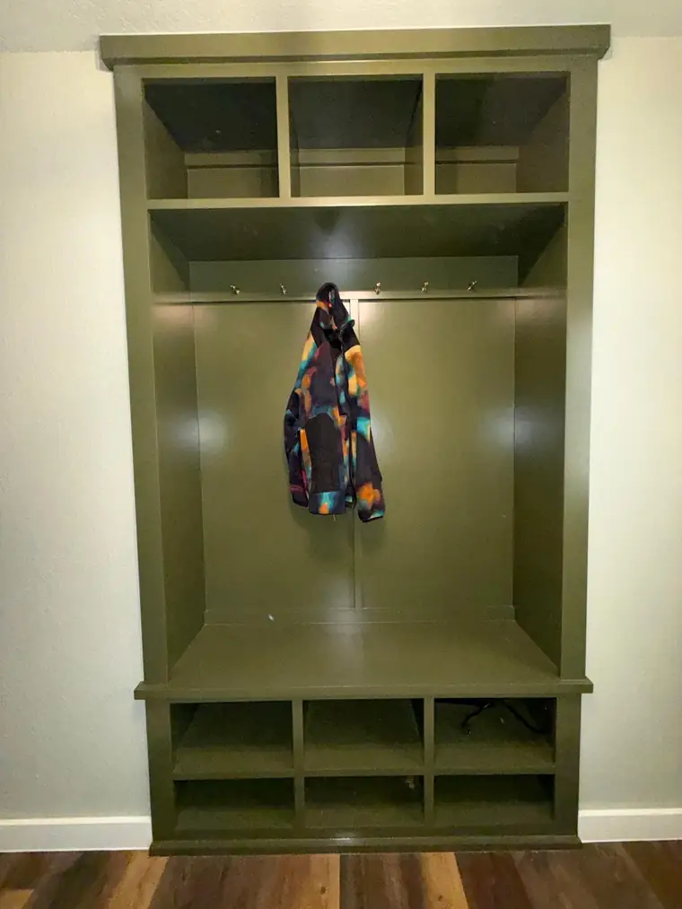 Olive mudroom locker unit with coat hooks, bench and cubbies