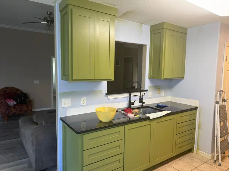 Olive green shaker kitchen with granite countertops and brass hardware