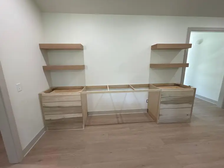 Unfinished built-in desk and floating shelves during construction