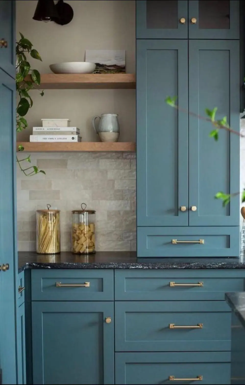 Teal blue shaker cabinets with brass pulls and white oak floating shelves