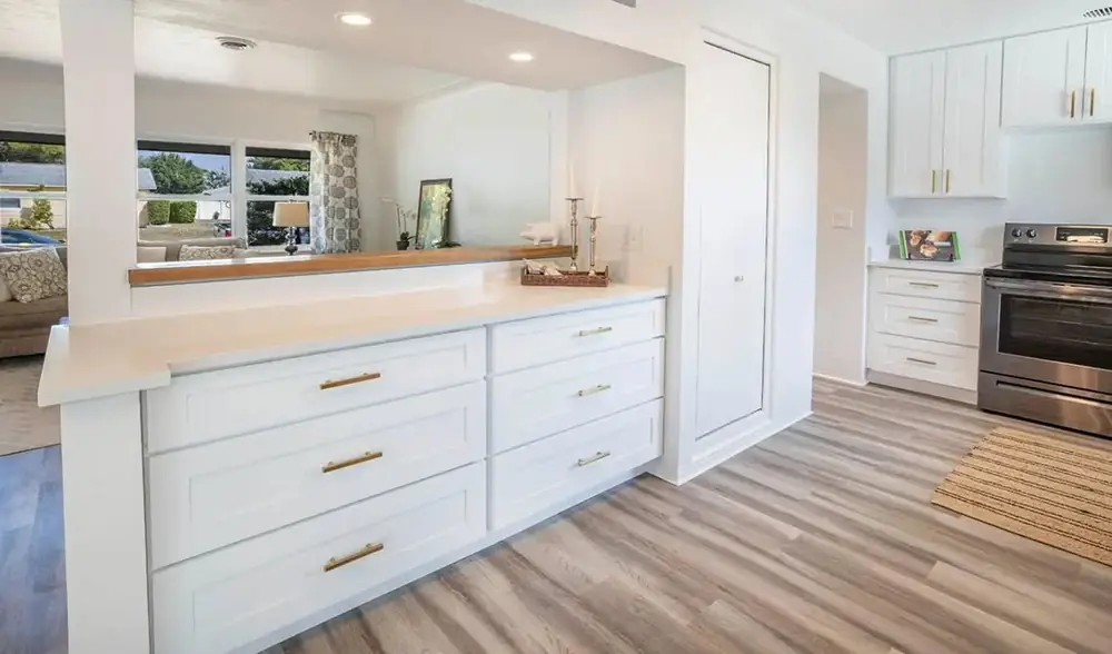 White shaker drawer bank and pass-through bar with brass pulls