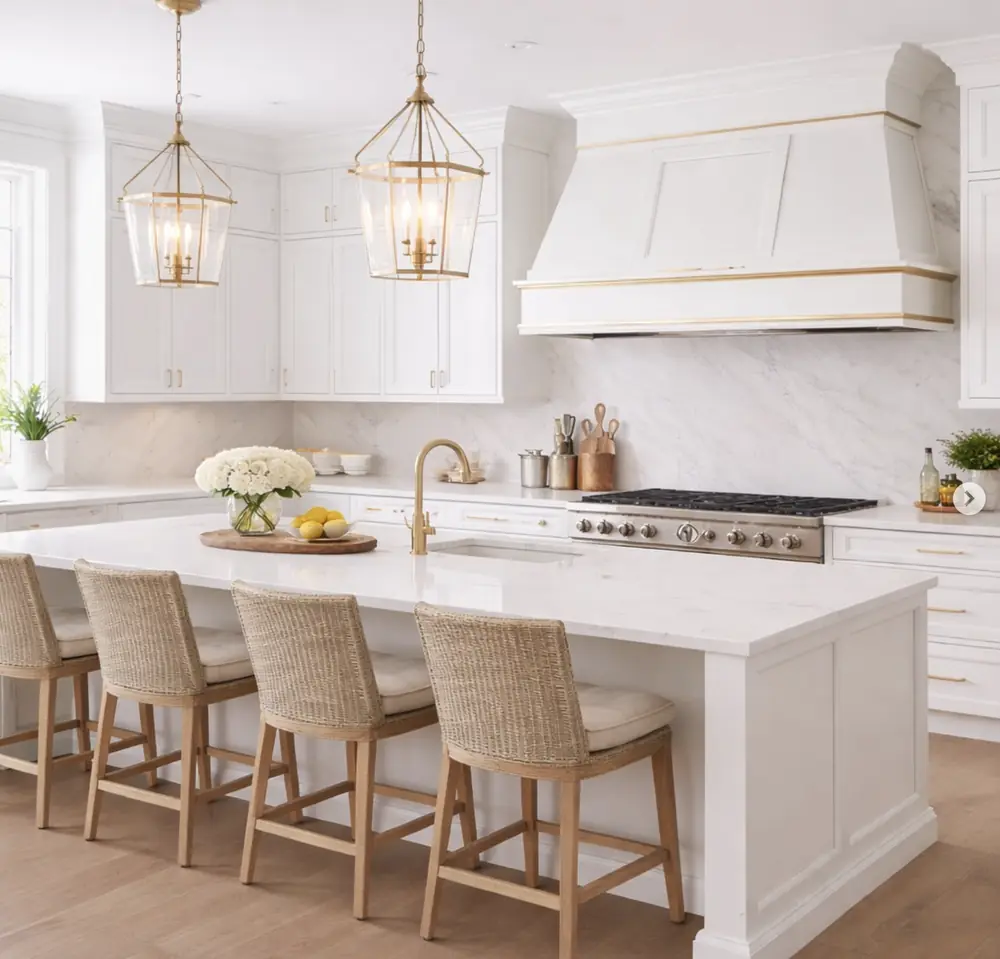 White cabinetry with a brass trimmed hood surround and marble backsplash